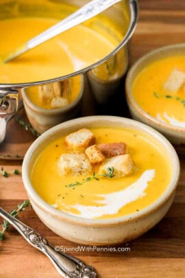 pot full of Butternut Squash Soup with plated bowls and croutons