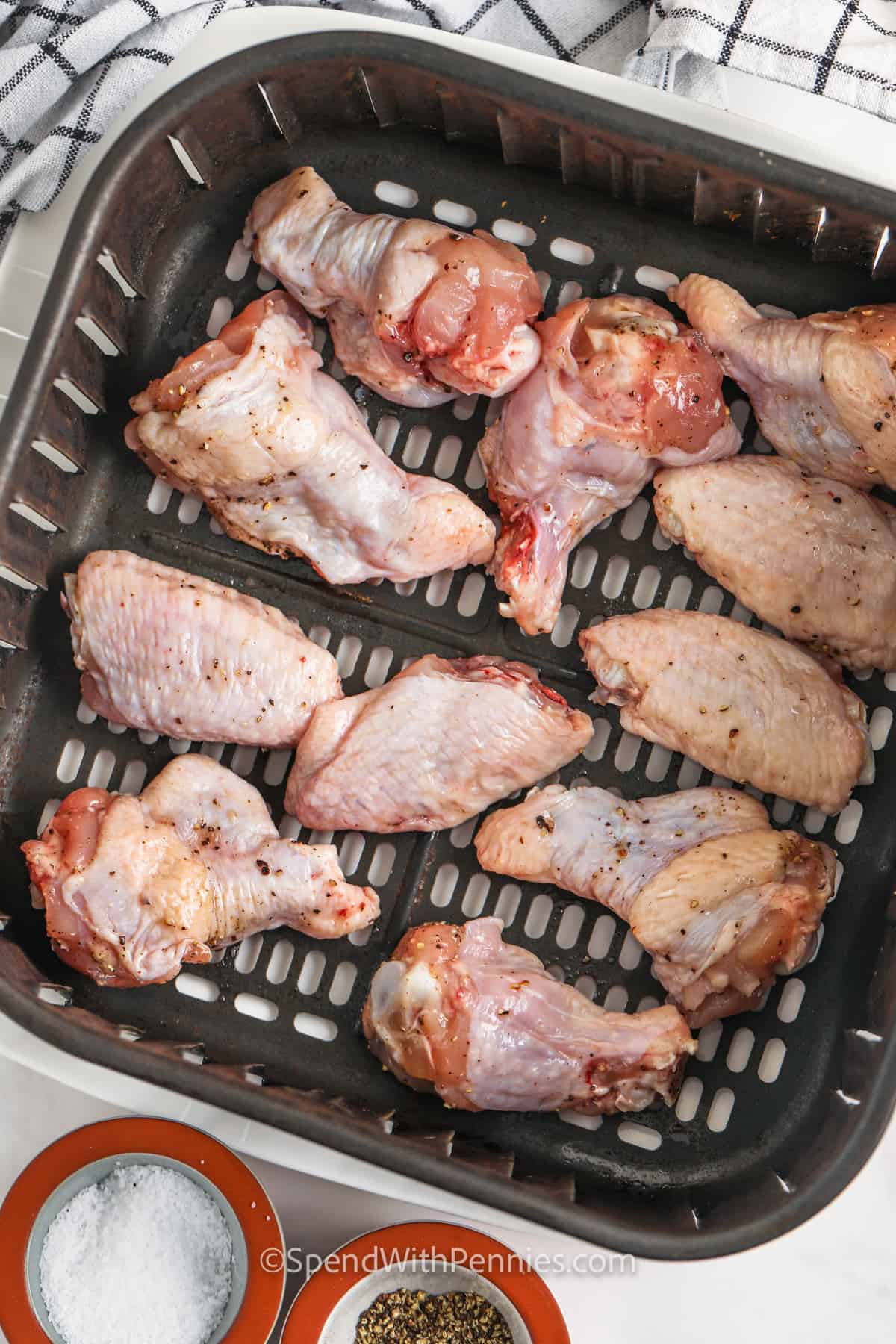 adding chicken to fryer to make Air Fryer Chicken Wings