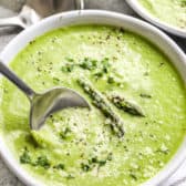 Asparagus Soup in a white bowl with a spoon