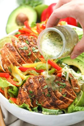 pouring dressing on to Chicken Fajita Salad