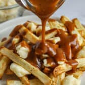 adding gravy to fries to make a Poutine