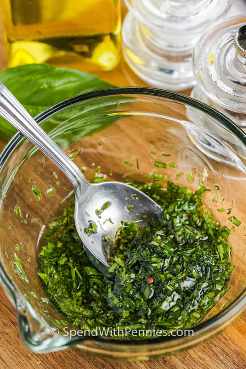 mixing herbs with oil to make Roasted Patty Pan Squash dressing