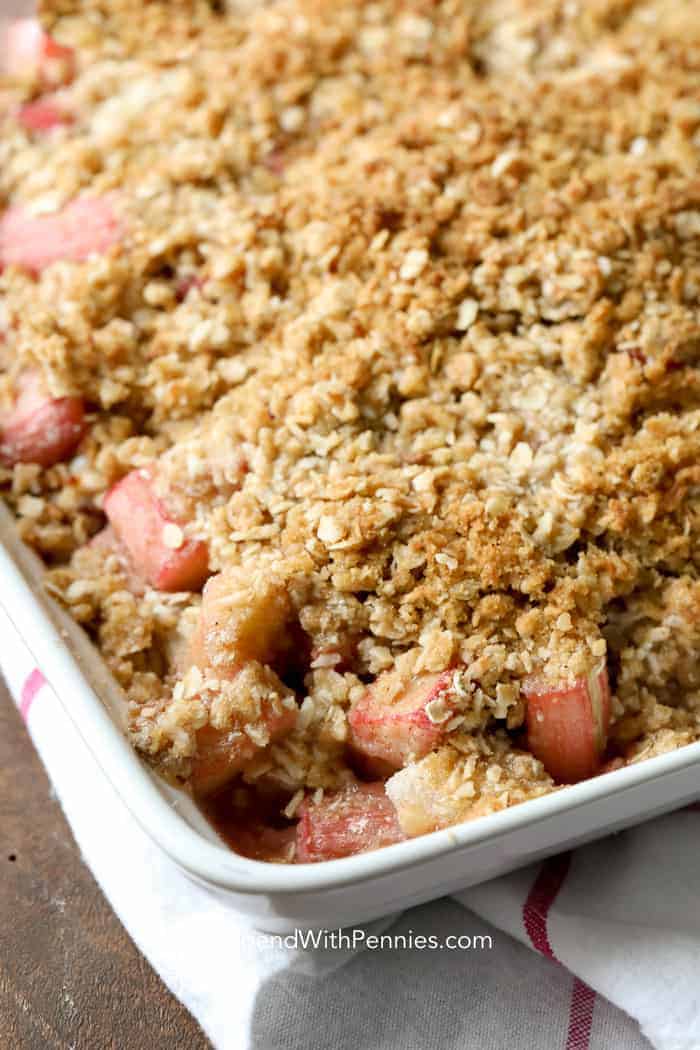 Simple, tart and delicious this old fashioned Rhubarb Crisp recipe is perfect for fall as you harvest your fruit! This easy Rhubarb Crisp is a delicious and easy dessert you can make in minutes! With the perfect balance between sweet and tart, rhubarb crisp is going to be your new summer favorite. #spendwithpennies #easyrecipe #easydessert #rhubarbcrisp #strawberryrhubarb #withoatmeal #bakedrecipe #fruitcrisp Rhubarb Crisp prepared golden and brown in a baking dish