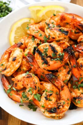Sriracha Grilled Shrimp on a white plate with lemon slices