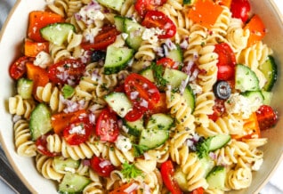 an an easy pasta salad in a white serving bowl with parsley